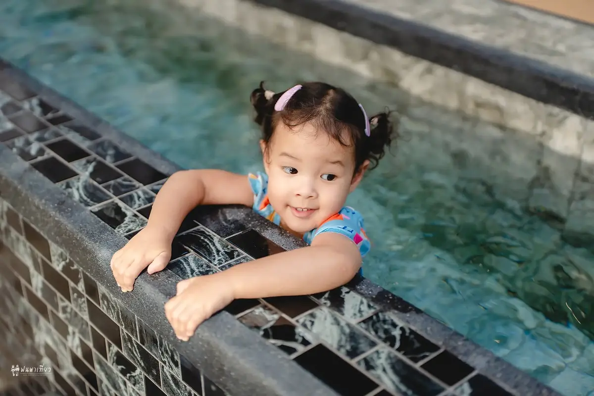 Child smiling at the pool edge