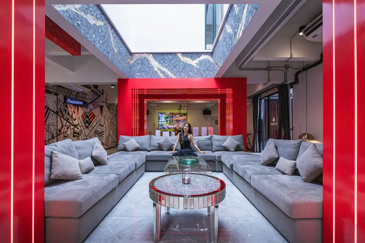 Red lounge with a large grey sofa under a skylight