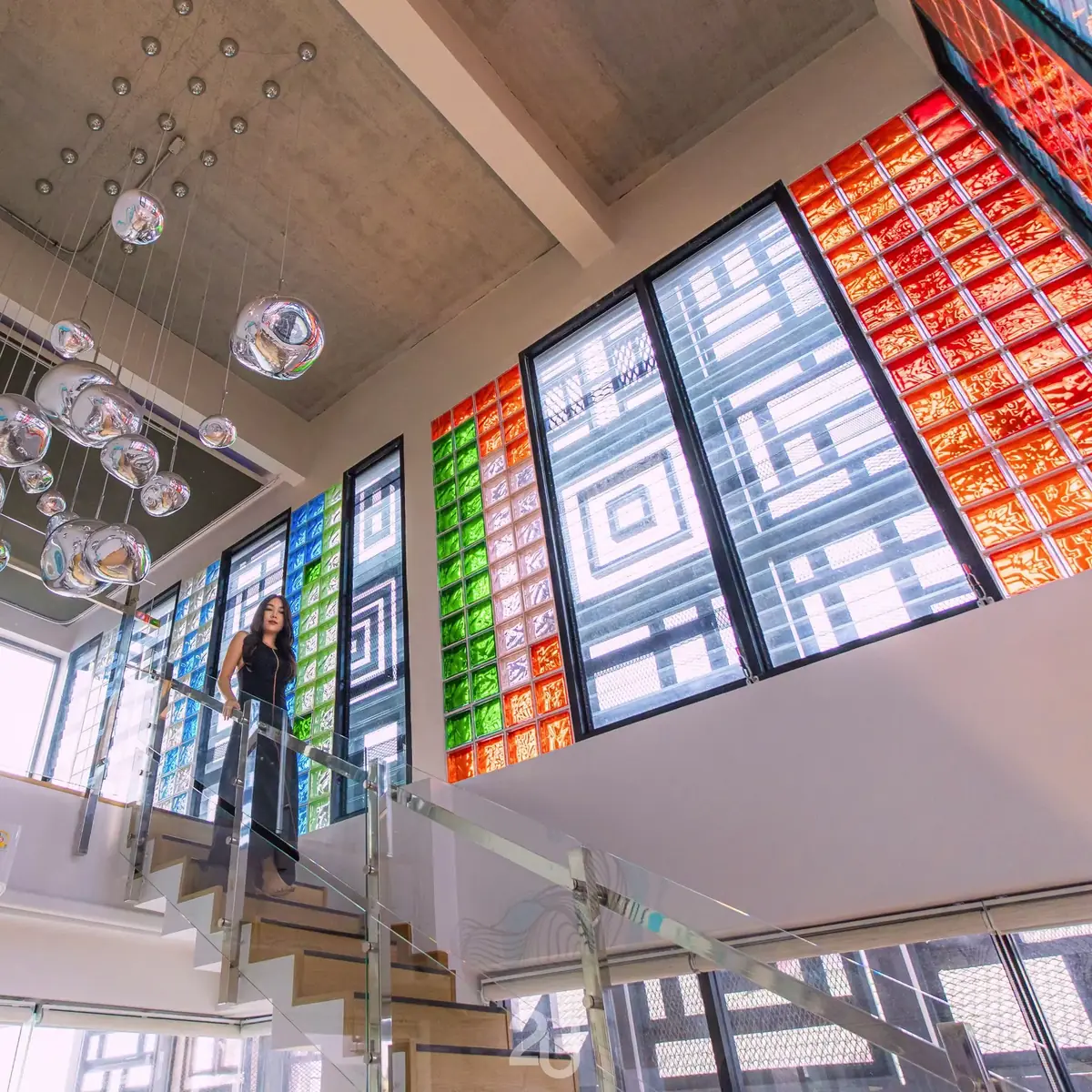 Glass staircase beside colourful stained-glass windows